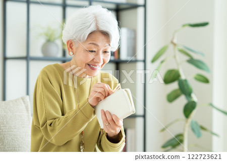 Senior woman looking at her wallet Senior woman looking at her wallet 122723621