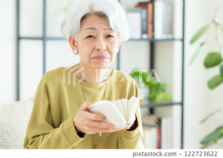 Senior woman looking at her wallet Senior woman looking at her wallet 122723622