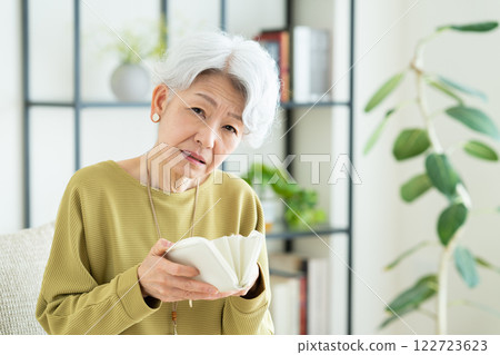 Senior woman looking at her wallet Senior woman looking at her wallet 122723623