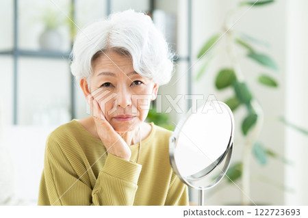 senior woman looking in the mirror 122723693