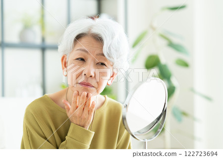 senior woman looking in the mirror 122723694