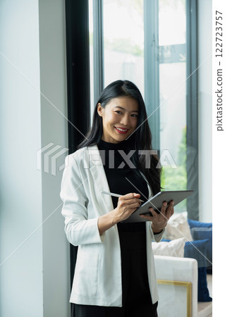Businesswoman working using tablet. 122723757