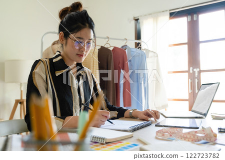 Young clothing designer envisions new ideas in studio. 122723782