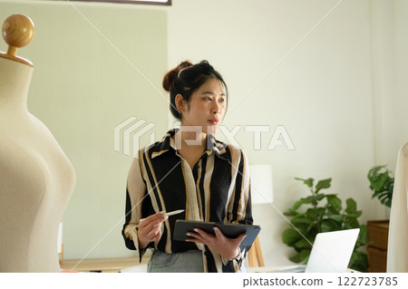 Young clothing designer working with tablet. 122723785