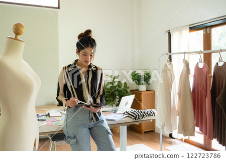 Young clothing designer working with tablet. 122723786