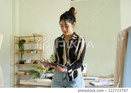 Young clothing designer working with tablet. 122723787