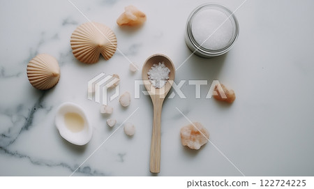 Luxurious spa product setup featuring body scrub, bamboo spoon, and sea salts arranged elegantly on marble with warm lighting for a soothing experience 122724225
