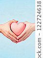 A pink heart between masculine and feminine hands. AI generated image. 122724638