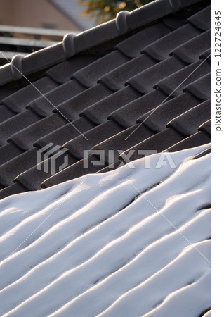 The snow that has accumulated on the Japanese tile roofs begins to melt. 122724645