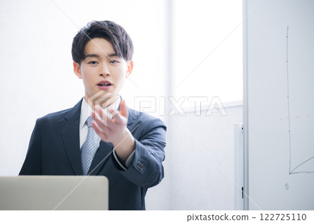 A businessman asking a question to someone during a presentation A businessman asking a question to someone during a presentation 122725110