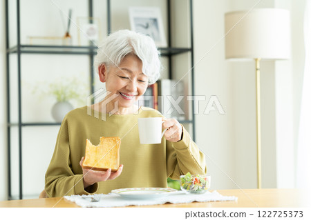 Senior woman eating bread for breakfast 122725373