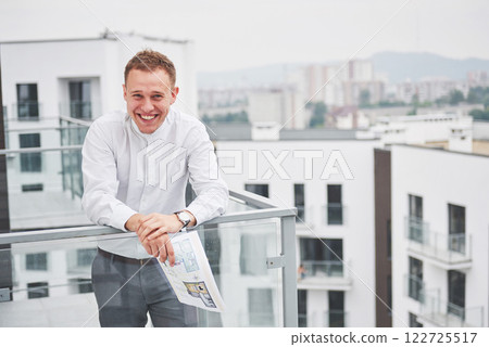 Smiling young architect or engineering builder in hard hat with tablet over group of builders at construction site, architect watching some a construction, business, building, industry, people concept 122725517