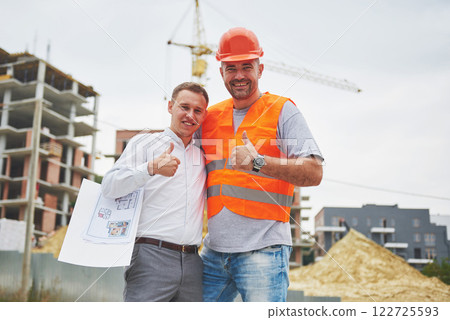 construction, architecture, business, teamwork and people concept - happy architects with blueprint at building site construction, architecture, business, teamwork and people concept - happy architects with blueprint at building site 122725593