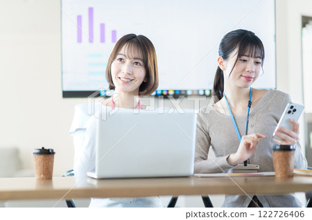 A young businesswoman having a meeting while holding documents 122726406