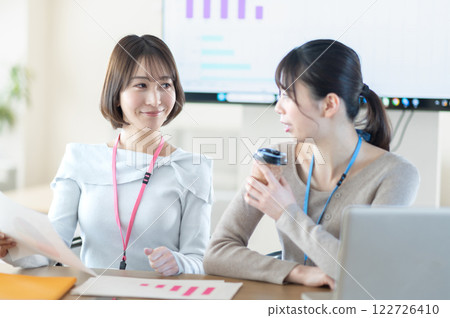 A young businesswoman having a meeting while holding documents 122726410