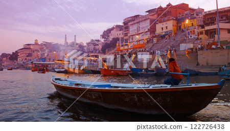 Varanasi, Uttar Pradesh, India. Many Boats moored on Ganga river near ghats. Hundreds of tourists and locals come in boats to watch Ganga Maha Aarti ceremony and the fire ceremony. Purple sunset sky 122726438