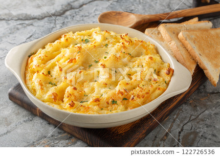 Fluffy delicious baked mashed potatoes with cheese, cream and butter close-up in baking dish. Horizontal 122726536