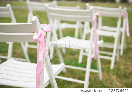Freshly cut beautiful red and purple wedding flowers garland on chair Freshly cut beautiful red and purple wedding flowers garland on chair 122726603