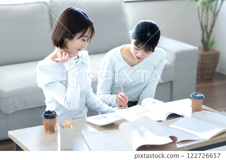 Two female students studying while being taught Two female students studying while being taught 122726657