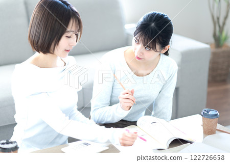 Two female students studying while being taught Two female students studying while being taught 122726658