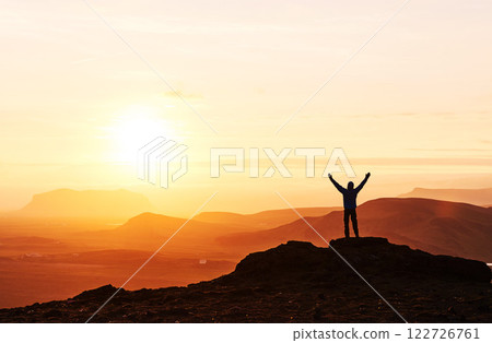 Silhouette of a man on a mountain top. Person silhouette on the rock. Sport and active life concept 122726761