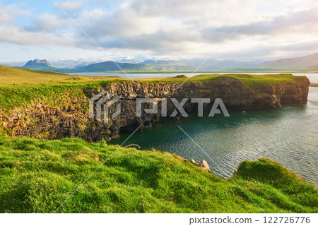 Cape Dyrholaey at southern Iceland. Altitude 120 m, and mean hill island with a door opening 122726776