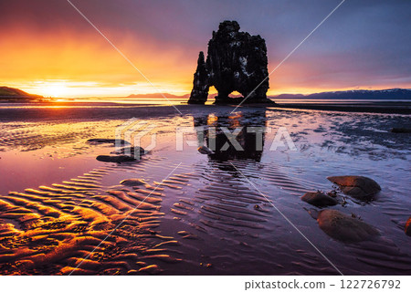Is a spectacular rock in the sea on the Northern coast of Iceland. Legends say it is a petrified troll. On this photo Hvitserkur reflects in the sea water after the midnight sunset 122726792