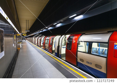 London Underground Train Stopped at an Empty Platform with Bright Station Lights 122727249