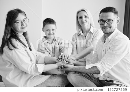 Portrait of family like big and supportive team. Parents showing to kids their support. Family playing games at home. Black and white image. 122727269