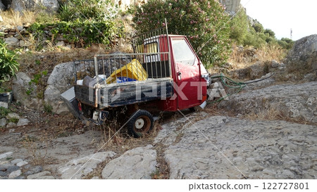 An abandoned tricycle van on a hill. 122727801