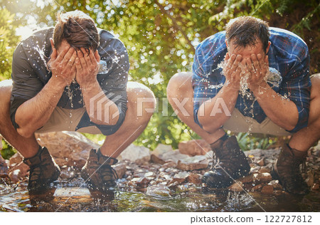 Hiking men splash face with water for cool, relax and cleaning dirt when trekking on rock or hike in countryside forest. Earth, freedom after camping in nature and travel along mountain river or lake Hiking men splash face with water for cool, relax and cleaning dirt when trekking on rock or hike in countryside forest. Earth, freedom after camping in nature and travel along mountain river or lake 122727812