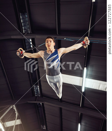 Fitness, sports and gymnastics man training on rings for strong arms, balance and power for his high energy exercise. Sports, body and young male athlete doing routine, flexible and agility workout 122727885