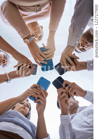 Social media, smartphone and business people networking with a global community using technology together. Group and team typing, surfing and searching online on web communication app from below view 122727900