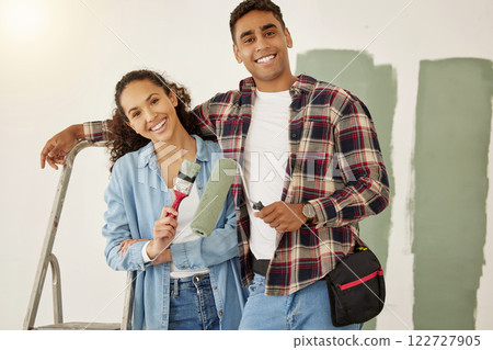 Painting, love and home with a couple doing DIY, renovation and house remodel with a paintbrush and roller. Domestic relationship and teamwork with a man and woman ready to paint a room 122727905