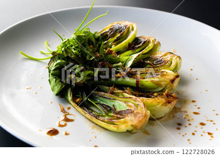 Fresh bok choy is elegantly plated, showcasing a vibrant green garnish inspired by Asian cuisine. 122728026