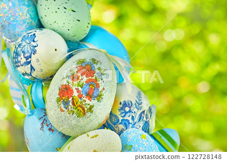 Easter.Spring blue bouquet of colorful painted eggs on green tree 122728148
