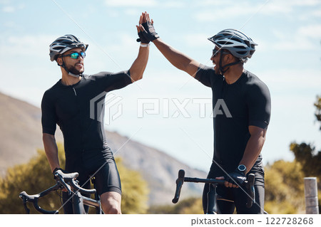 High five, winner and cycling team of cyclists having fun riding together outdoors in nature. Happy, excited and fit male bicycle riders on a break after exercising and training in the environment 122728268