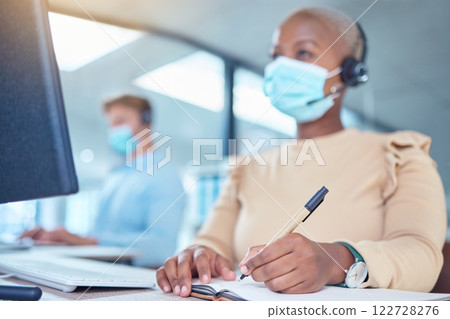 Writing, documents and covid of a woman with a mask while at work in customer support in a call center. Female contact agent in telemarketing helping client and taking notes on a desk at the office. 122728276