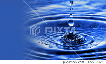 Close-Up of Water Droplets Forming Ripples on Vibrant Blue Surface 122728428