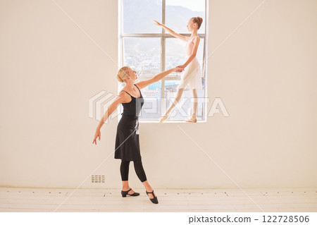 Art, ballet and dance teacher with girl ballerina practicing posture by a window in a studio. Creative child dancer training with an instructor for a recital concert. Young student dancing with coach Art, ballet and dance teacher with girl ballerina practicing posture by a window in a studio. Creative child dancer training with an instructor for a recital concert. Young student dancing with coach 122728506