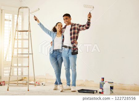 Portrait of happy couple painting the new living room in a home or apartment. Man and woman with paintbrush to decorate a wall color and renovation the house interior with smile or happiness together Portrait of happy couple painting the new living room in a home or apartment. Man and woman with paintbrush to decorate a wall color and renovation the house interior with smile or happiness together 122728556