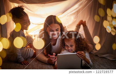 Mother, children and tablet with happy family watching online tv, learning with education games and reading ebook at night at home. Internet and enjoying live stream movies with cartoon subscription 122728577