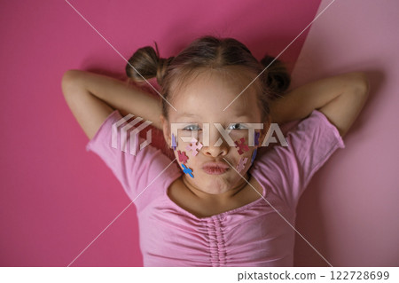 The girl decorated cheeks with an autism symbol and sends an air kiss as a sign of support and concern for people with autism spectrum disorder. The girl decorated cheeks with an autism symbol and sends an air kiss as a sign of support and concern for people with autism spectrum disorder. 122728699