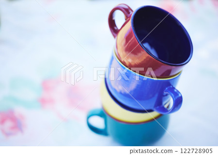 Group of cup for coffee or tea picnic, breakfast or food and drink catering event. Stack of colorful ceramic kitchen mug on creative park, restaurant or zen garden table with flower and plant design Group of cup for coffee or tea picnic, breakfast or food and drink catering event. Stack of colorful ceramic kitchen mug on creative park, restaurant or zen garden table with flower and plant design 122728905