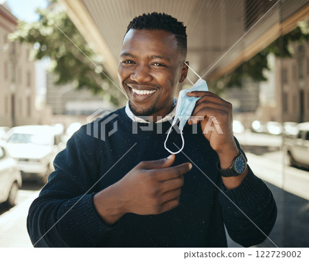 Post covid travel, working businessman with mask in city after lockdown restrictions and pandemic. African worker travel, closeup portrait employee smiling and change covid19 job safety regulations. Post covid travel, working businessman with mask in city after lockdown restrictions and pandemic. African worker travel, closeup portrait employee smiling and change covid19 job safety regulations. 122729002