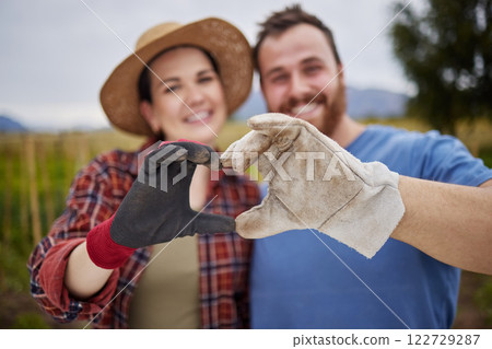 Farmer or gardener couple showing love heart sign with their hands outdoors on an organic or sustainable farm. Happy and excited activists support sustainability or organic farming Farmer or gardener couple showing love heart sign with their hands outdoors on an organic or sustainable farm. Happy and excited activists support sustainability or organic farming 122729287