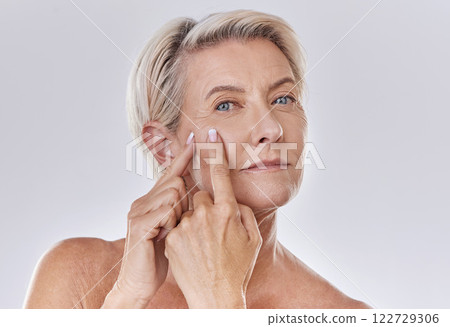 Acne or pimple popping senior woman while doing a skincare beauty treatment for healthy and clear skin. Portrait of happy old, mature or elderly female squeezing a spot on her face 122729306