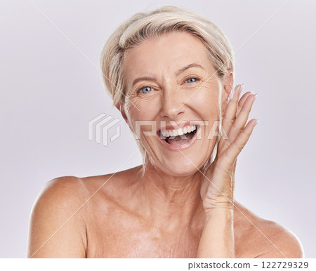 Portrait of a happy woman showing healthy skin with smile, advertising beauty skin care cosmetics and health wellness on grey studio background. Portrait of face of senior model doing self care 122729329