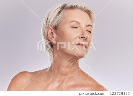 Beauty, skincare and face of a senior woman posing with closed eyes and topless against grey studio background. Happy old, elderly or mature female with glowing skin due to cosmetic self care Beauty, skincare and face of a senior woman posing with closed eyes and topless against grey studio background. Happy old, elderly or mature female with glowing skin due to cosmetic self care 122729333