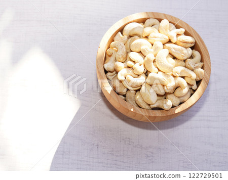 Cashew nuts in wooden bowl on white table with sunshine. Healthy food. 122729501